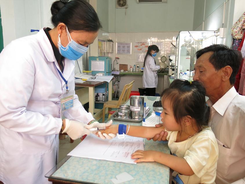 Cán bộ y tế bệnh viện đang lấy máu xét nghiệm cho bệnh nhân