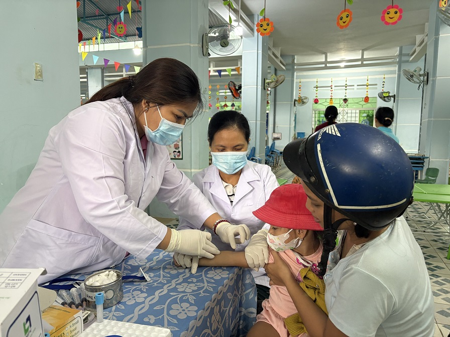 Cán bộ y tế Trung tâm Kiểm soát bệnh tật lấy máu xét nghiệm cho trẻ tại Trường Mầm non An Lão (Ảnh: Thu Phương)