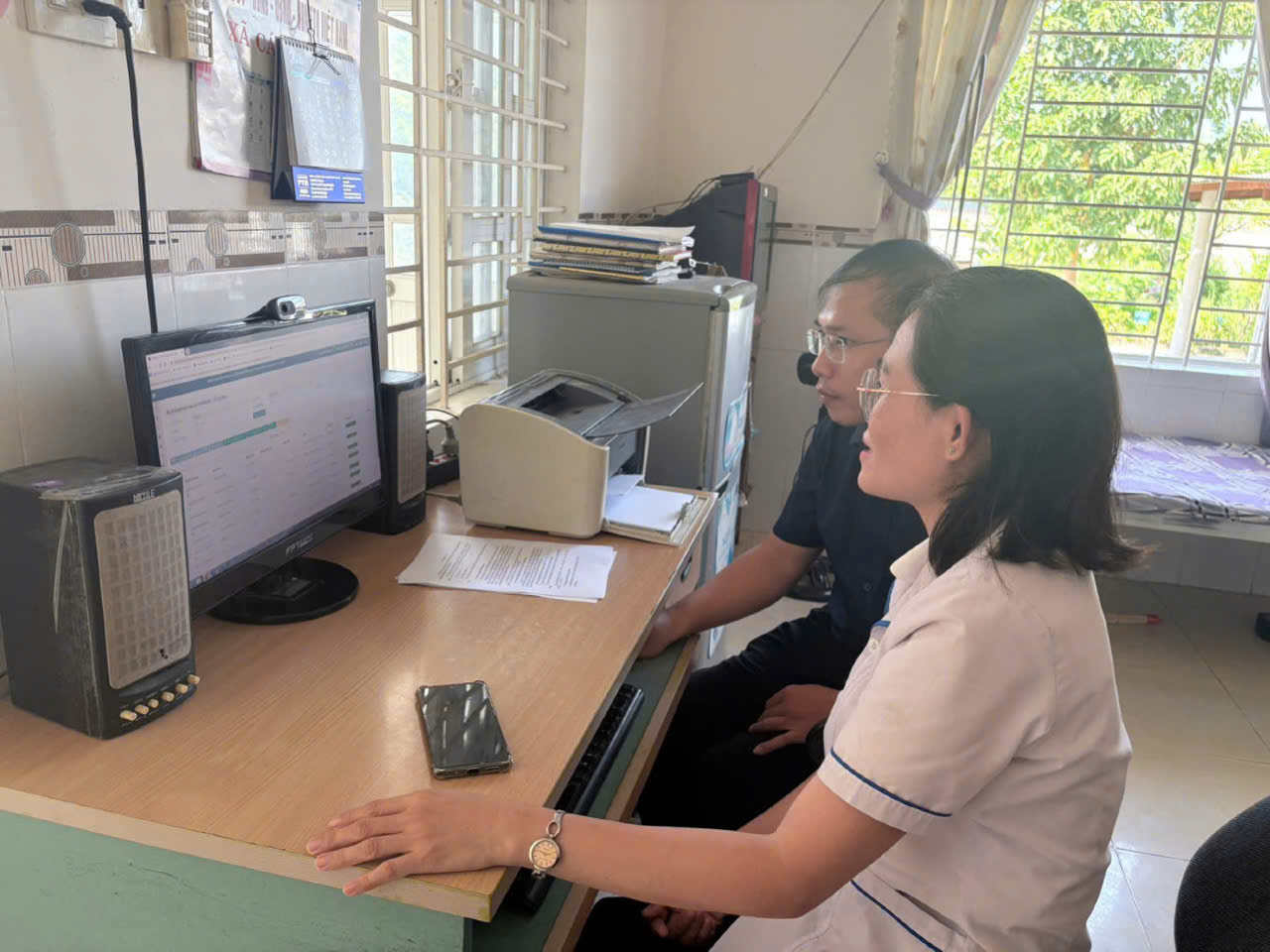 Đoàn công tác hướng dẫn cán bộ y tế sử dụng Hệ thống quản lý thông tin tiêm chủng quốc gia tại Trạm Y tế xã Xuân An (Ảnh: Thu Phương)