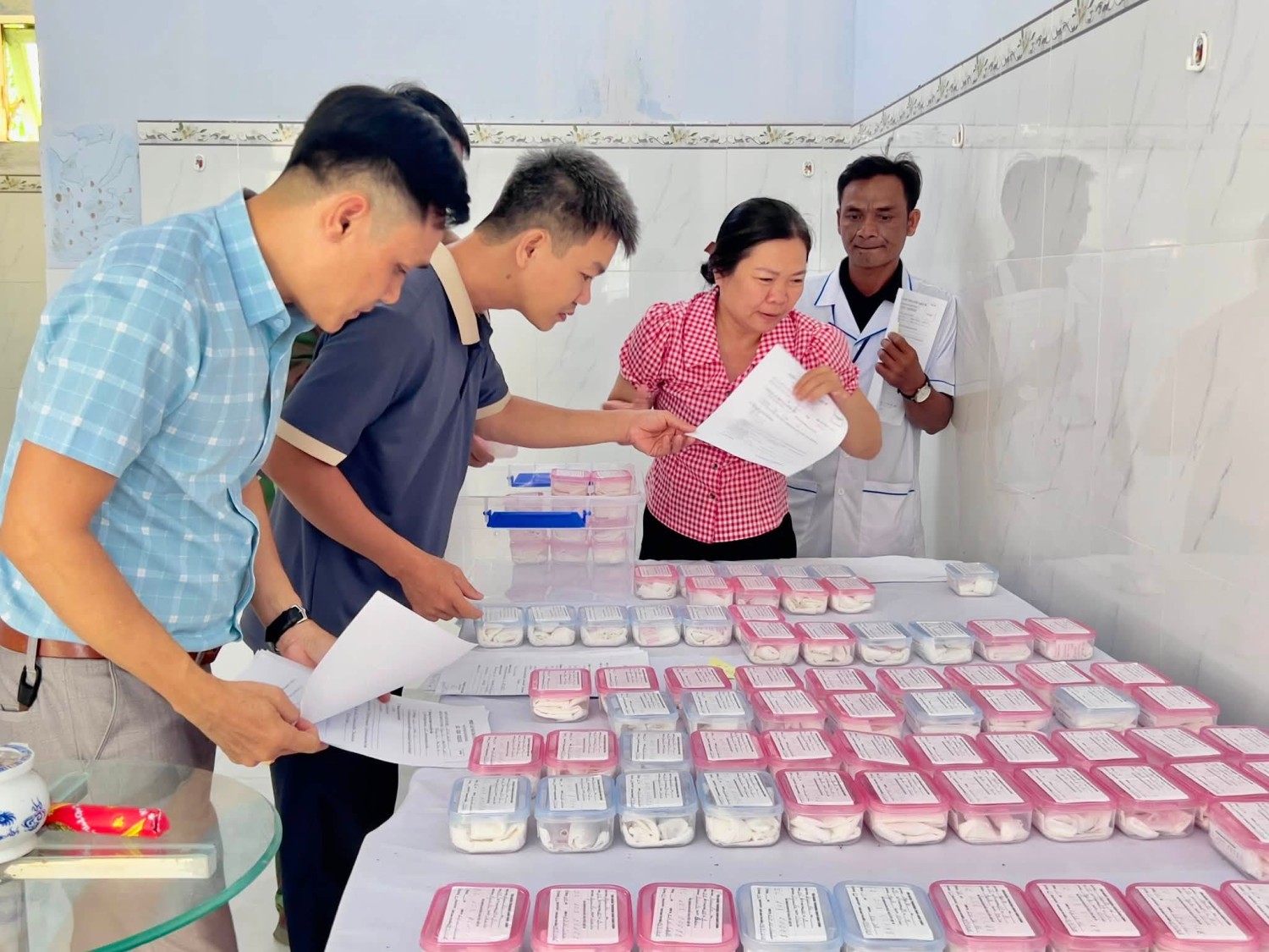 Nhân viên Trung tâm Y tế Ayun Pa kiểm tra lại danh sách các mẫu hài cốt trước khi bàn giao. (Ảnh do đơn vị dung cấp)